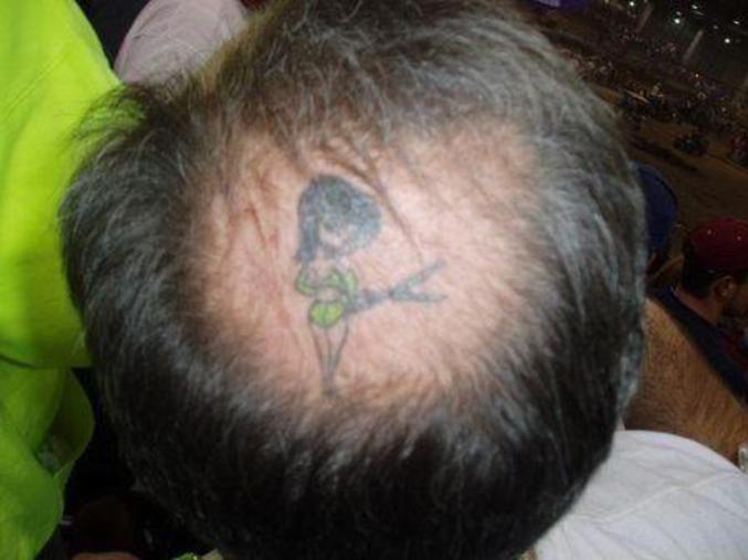 Un tatouage original sur la tête d'un homme qui commence à perdre ses cheveux.