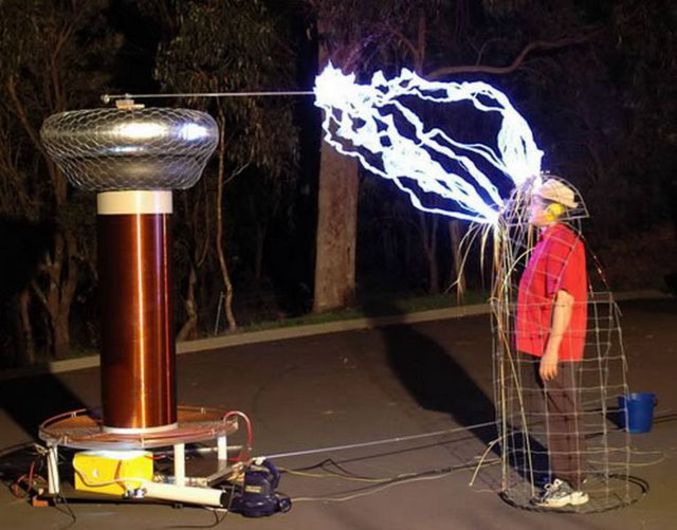 Un homme dans une cage Tesla protégé d'un arc impressionnant