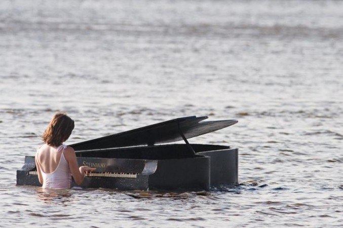 Une femme joue du piano dans la mer.