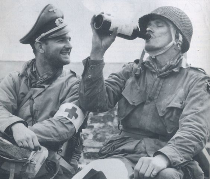 Un infirmier américain partage une bière avec un prisonnier américain, qu'il vient de soigner. Probablement durant la bataille des Ardennes, décembre 1944.
