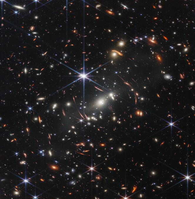 Selon la Nasa, cette première image du télescope spatial James Webb « est l’image infrarouge la plus profonde et la plus nette de l’univers lointain à ce jour ». Elle cible l’amas de galaxies SMACS 0723
L’Agence spatiale européenne souligne que « la masse combinée de cet amas de galaxies agit comme une lentille gravitationnelle, magnifiant des galaxies beaucoup plus lointaines derrière elle », ce qui donne cet effet de courbure autour du centre de l’image. L’amas est apparu il y a 4,6 milliards d’années et cette image permet de révéler des structures jamais vues auparavant.

L'image ici:
https://esawebb.org/images/webb-first-deep-field/