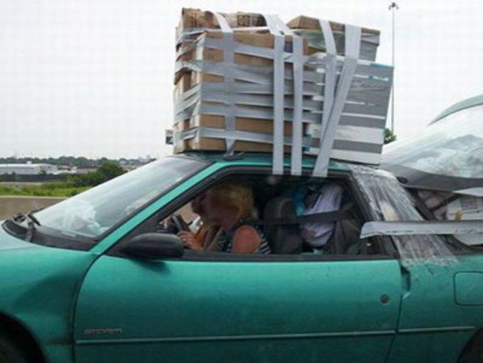 Une voiture chargée avec des affaires attachées n'importe comment.