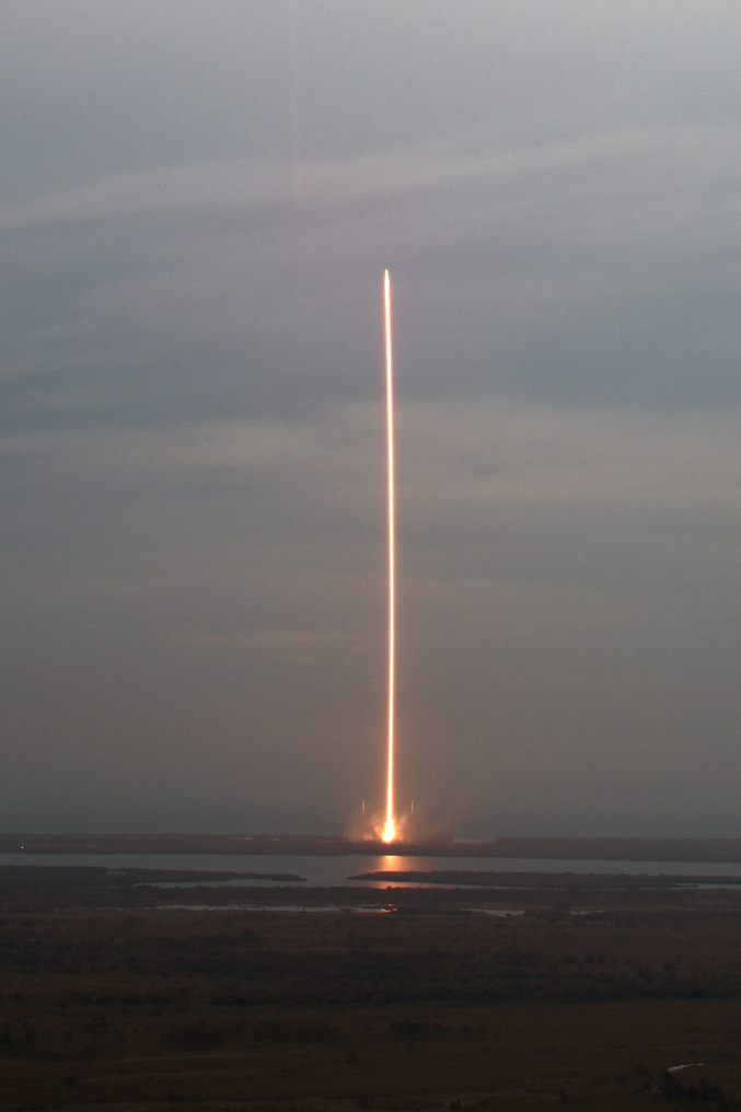 Une photo d'un lancement de fusée (Spacex lancement n°23) avec un long temps de pause, montrant la lumière des moteurs sous la forme d'une longue ligne.
