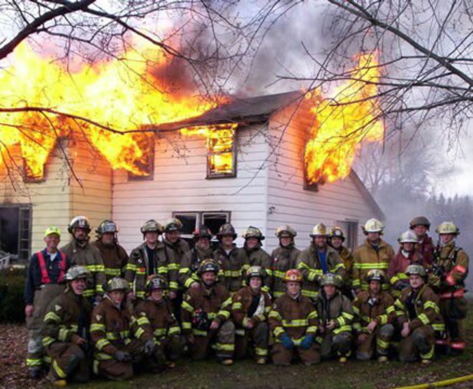 Des pompiers qui prennent la pause photo pendant un incendie.