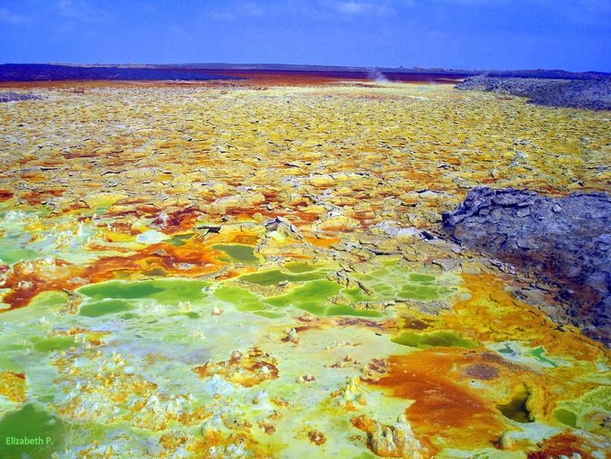 "Ce paysage incroyable s’est formé sur une terre de sel aride et blanche, où viennent s’ajouter les couleurs vert, rouge, orange, jaune, bleu ou ocre selon les endroits. Ces colorations sont dues à la présence de souffre, de sel et d’oxyde de fer qui y sont en grande concentration."

http://lacuriosphere.fr/2012/03/le-dallol-focus-sur-un-volcan-unique-au-monde/