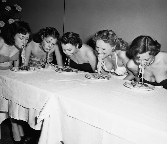 Mangée avec les mains jusqu'à la fin du XIXe siècle, la pasta appartient dans le sud de l'Italie à une longue tradition de cuisine de rue.
Ici, cinq filles de Broadway participent à un concours de "Spaghetti Swooshing" en 1948. Ou comment manger une assiette de spaghetti en sauce sans les mains !
