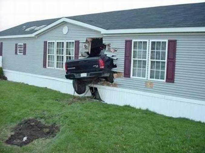 Une voiture accidentée dans une maison.