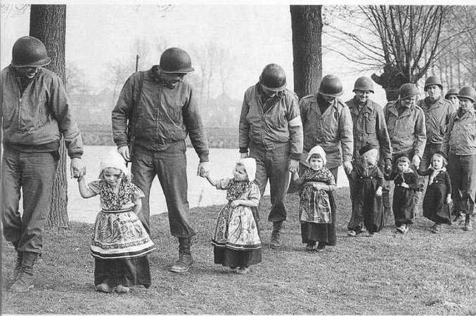 Des GI se rendent à une fête en leur honneur, emmenés par les enfants du village. Hollande, 1945.