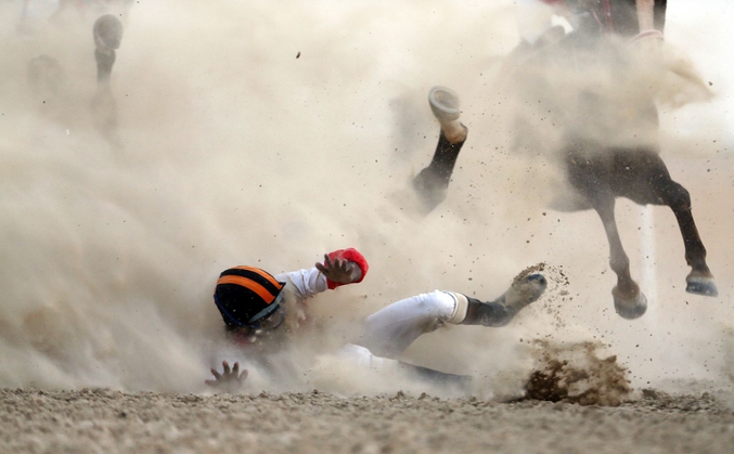 Un jockey et son cheval chutent lors d’une compétition du Festival du Chameau de Dhafra, Emirats Arabes Unis.