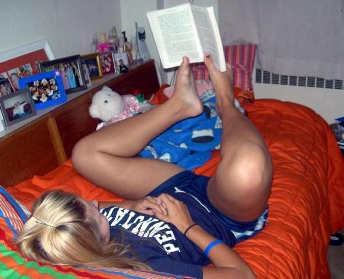 Une femme tient son livre avec ses pieds.