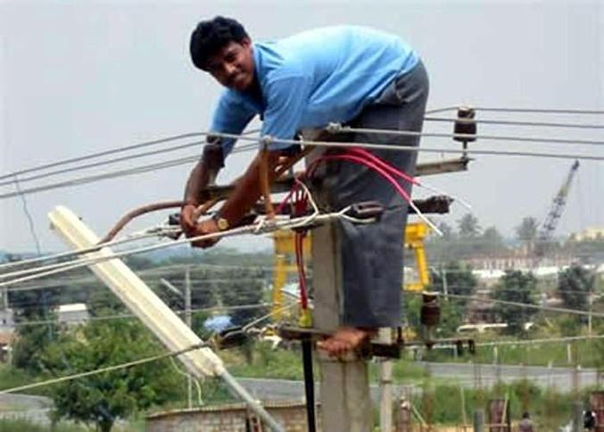 Un homme sans protection sur un poteau électrique.