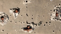 Trous de divers calibres dans un mur en Syrie