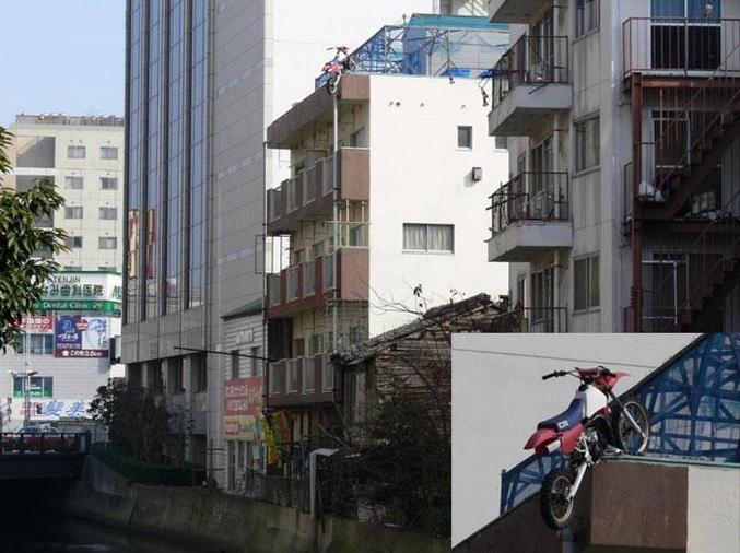 Une moto en équilibre sur le toit d'un bâtiment.