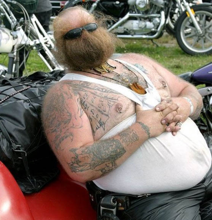 Un biker avec une barbe qui lui recouvre le visage.