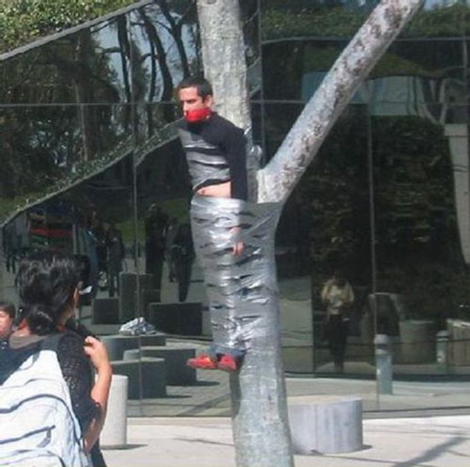 Un jeune attaché à un arbre.