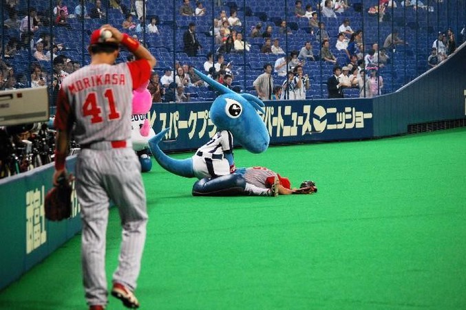 La mascotte d'une équipe de baseball vient redresser un joueur abattu.