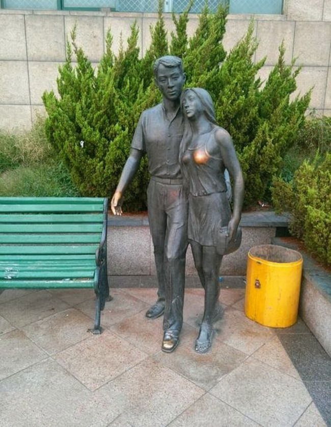 Une statue d'homme qui s'est beaucoup fait serrer la main et marcher sur le pied.
