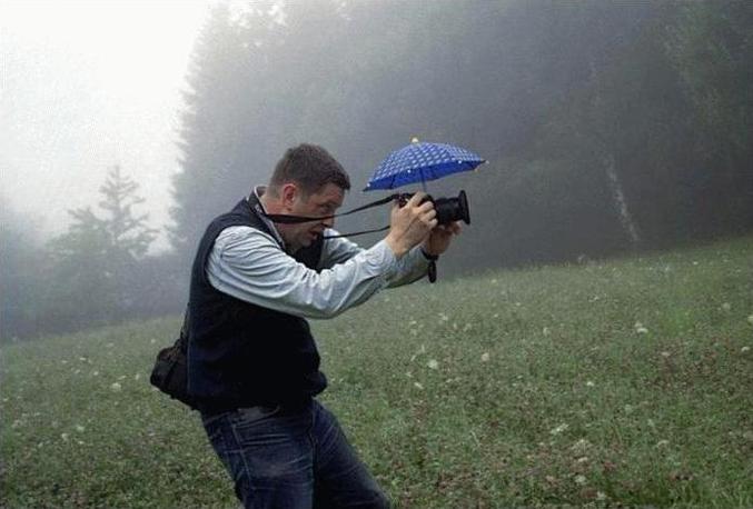 Un photographe équipé pour travailler sous la pluie.