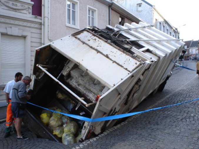 Un camion poubelle troue la chaussée