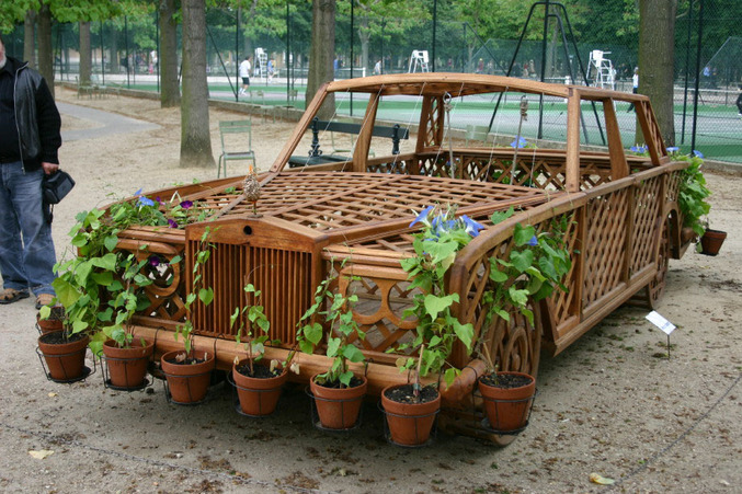 Une voiture de bois qui sert de jardinière.