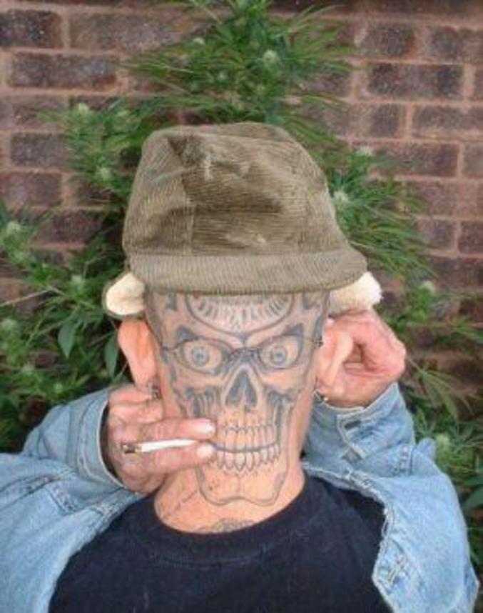 Un homme qui s'est fait tatouer une tête de mort derrière la tête.