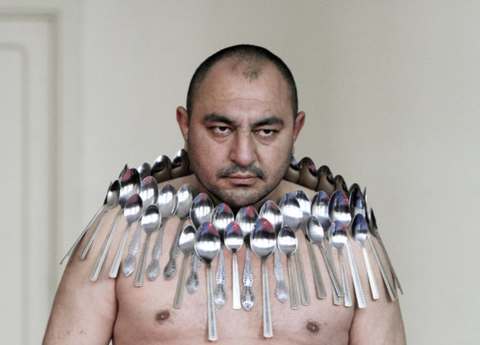 Etibar Elchiyev pose avec 50 cuillères en métal magnétisées sur son corps lors d'une tentative de record du monde homologué par les Guinness des records, à Tbilissi (Géorgie)