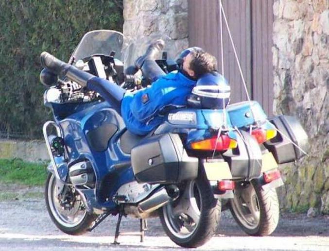 Un gendarme qui fait une petite sieste sur sa moto.