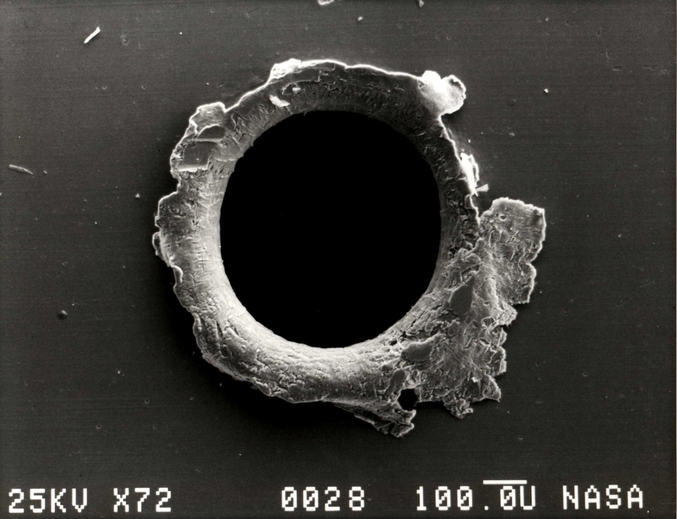 Apparemment le trou, vu ici agrandi, aurait été fait dans un des panneaux du satellite Solar Maximum Mission envoyé par la NASA.